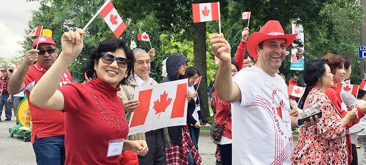 ISSofBC volunteers wave flags on Canada Day