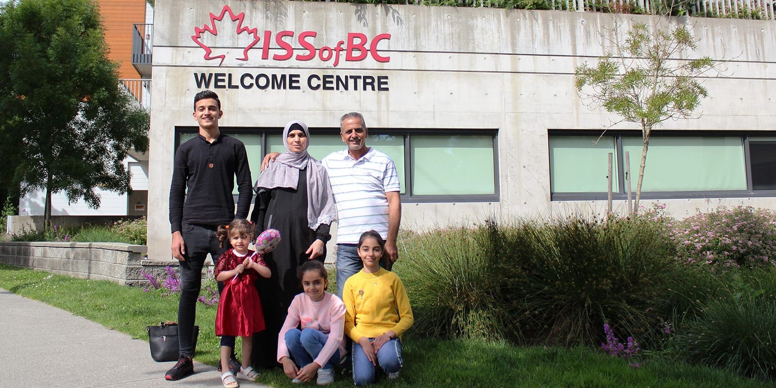 Refugee Family pose outside of ISSofBC Welcome Centre